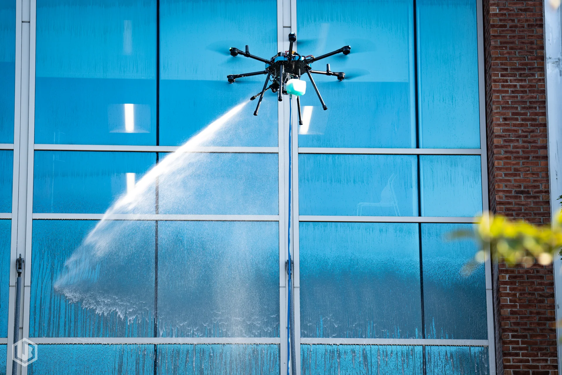 Drone spraying commercial blue-glass exterior windows