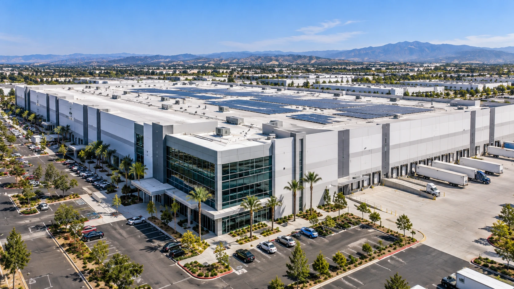Illustrative aerial view of a large commercial warehouse campus with a glass office entrance and rooftop solar panels
